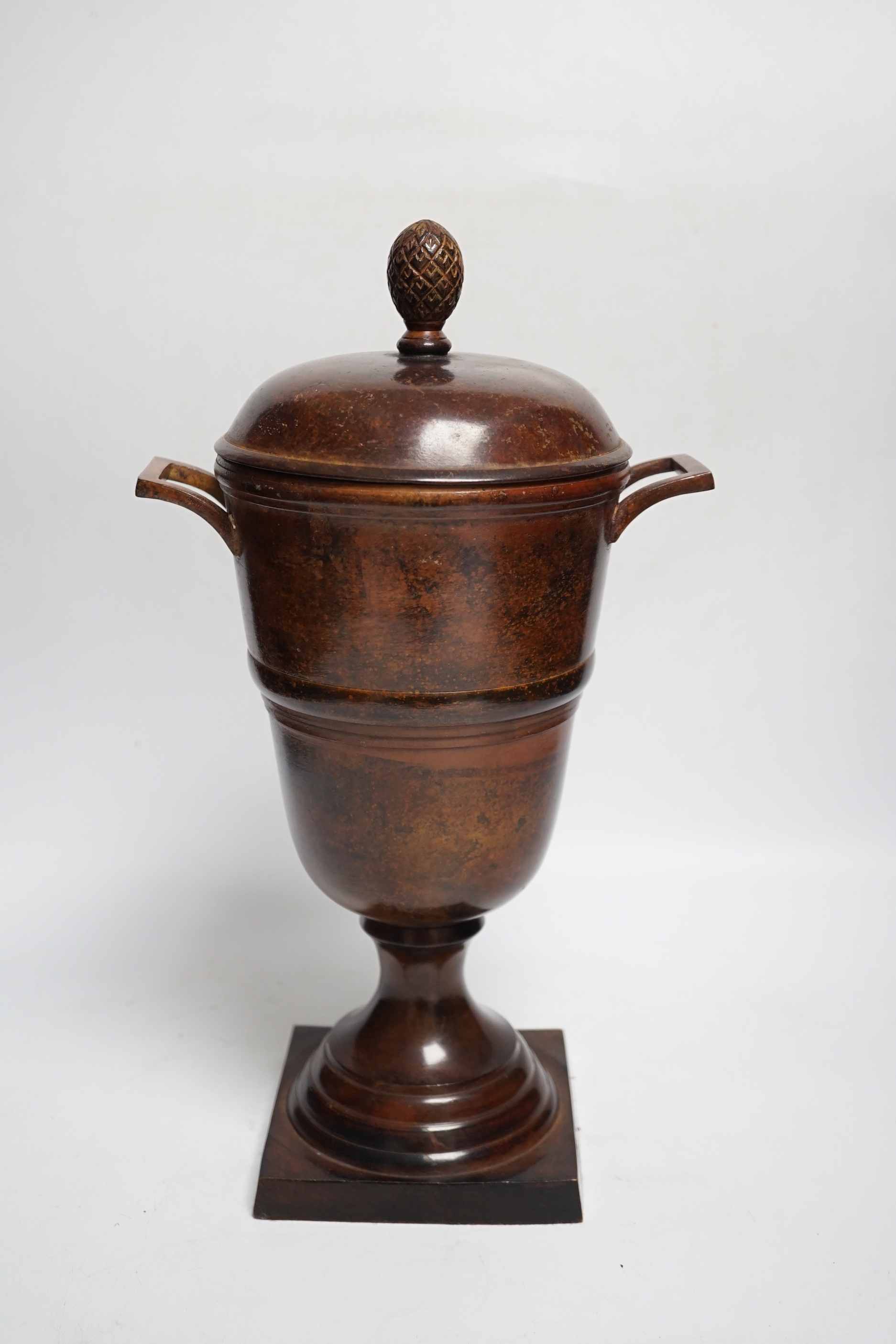 A patinated cast metal two-handled urn and cover with acorn finial, 36.5cm high